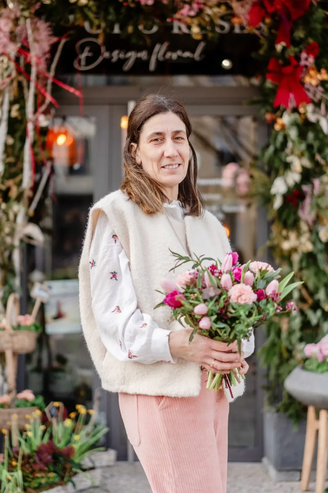 Portrait d'une fleuriste devant sa boutique, un bouquet à la main
