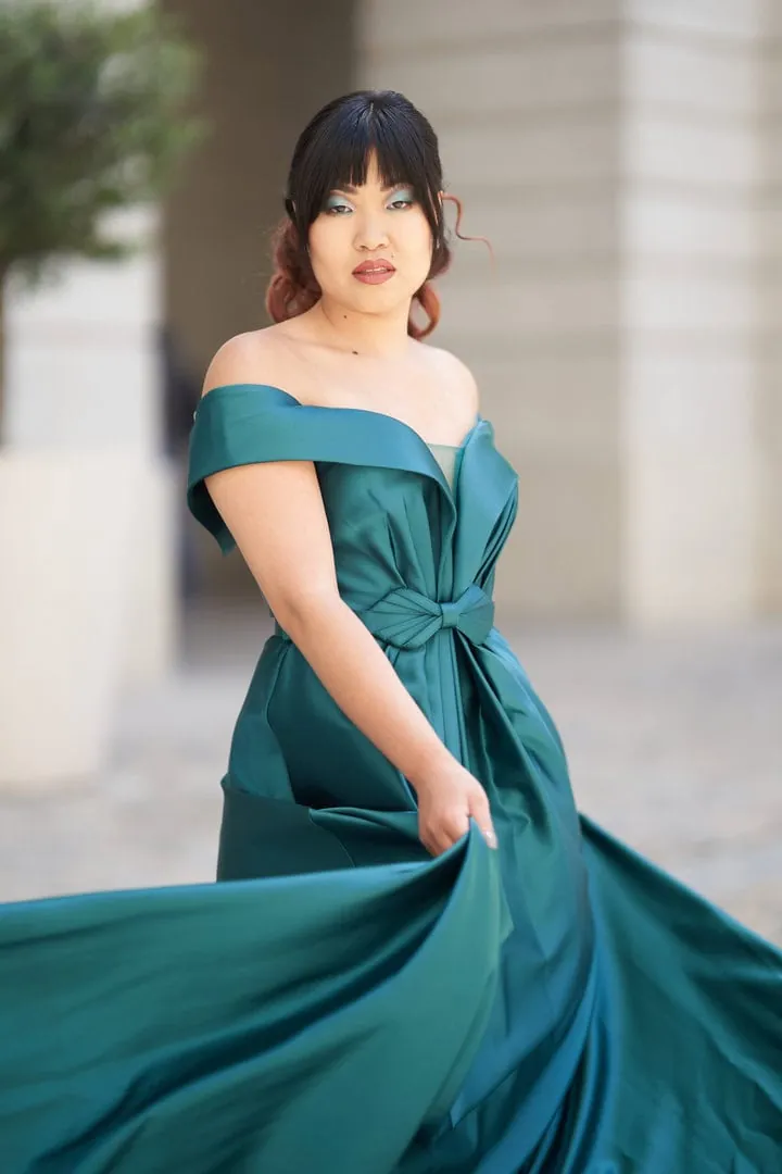 Femme en robe de soirée vert émeraude faisant virevolter sa jupe