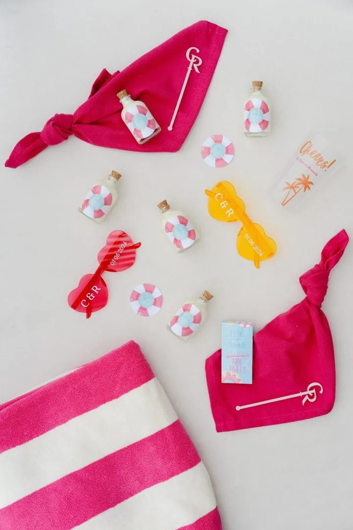 Produits d'une marque de crème solaire mis en scène façon plage, serviette rayée rose